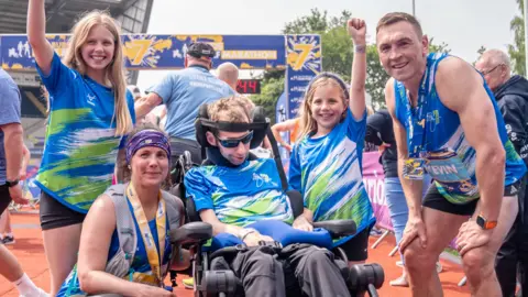 PA Rob Burrow pictured with his two daughters, wife Lindsey and best friend Kevin Sinfield at the Leeds Marathon