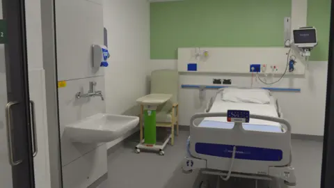 NUH A treatment room in the new unit, showing a hospital bed with sink and chair
