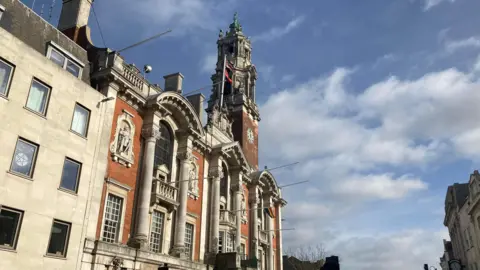 A general view of the exterior of Colchester Town Hall. The building extends over four storeys and has large windows and architectural details on its face.