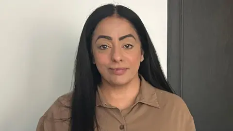 Arooj Shah has long black hair and is wearing khaki shirt