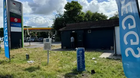 Janine Machin/BBC Signs for Greggs and Burger King at the scene of the fire