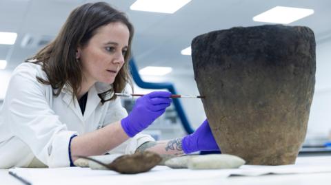 Conservator Bethan Bryan works on the Bronze Age Achmore Vessel