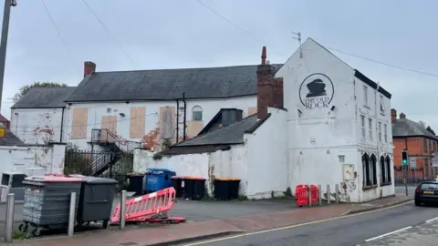 BBC A view looking at The Old Rock from Church Street in Stapleford, with peeling paint and boarded up windows visible.