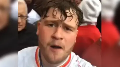 Jacob is wearing a Liverpool top and is in among the crowds celebrating in the city.
