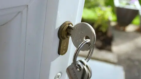 Close up of house keys in an open door