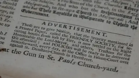 Shaun Whitmore/BBC A corner of a late 17th Century newspaper. Under a headline saying advertisement in capital letters, it outlines how the Friendly Society is advertising insurance cover to householders in case of fire. 