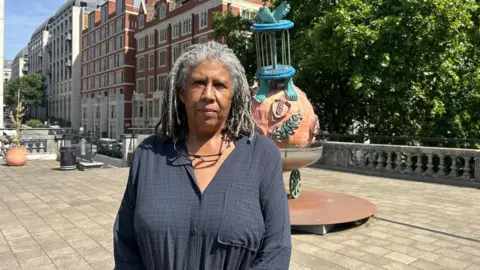 Lisa Vandy standing in front of a sculpture.