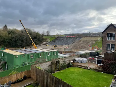 A building site next to a reservoir dam wall undergoing repair