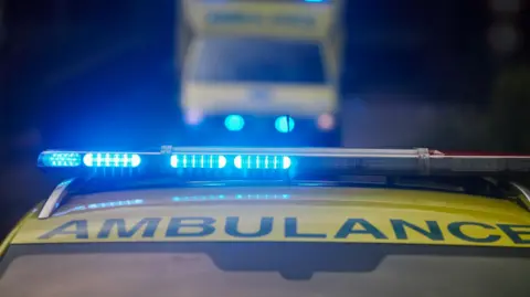 Getty Images The lights of an ambulance flash blue in the dark of the night.
