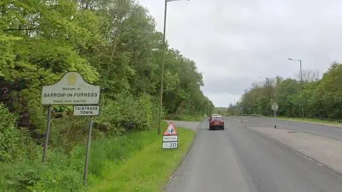 A Google Street View screenshot of the road entering Barrow, with a welcome sign.