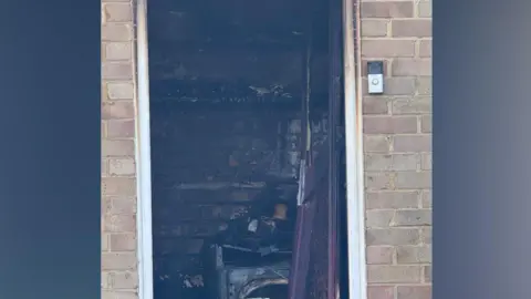 Supplied A close-up of a door to a room that appears badly damaged.