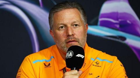 McLaren team boss Zak Brown holds a microphone during the team principals' news conference at the Miami Grand Prix