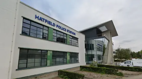 The outside of Hatfield Police Station - a dull-coloured building with windows and blue text reading "Hatfield Police Station"