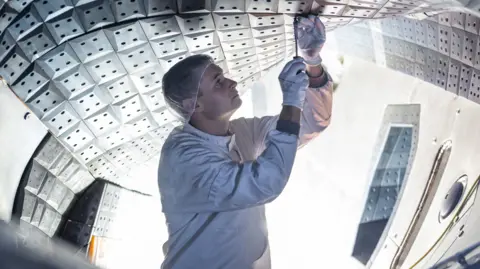 An engineer works inside the W7-X