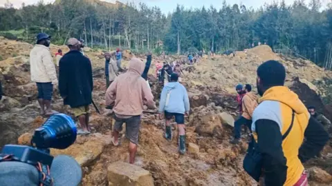 Getty Images | People gather at the site of a landslide in Maip Mulitaka in Papua New Guinea's Enga Province