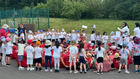 Children standing in the formation of a heart