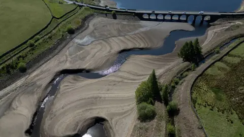 An aerial photo shows the bed of Woodhead Reservoir is partially revealed by a falling water level, near Glossop, northern England on May 9, 2025.
