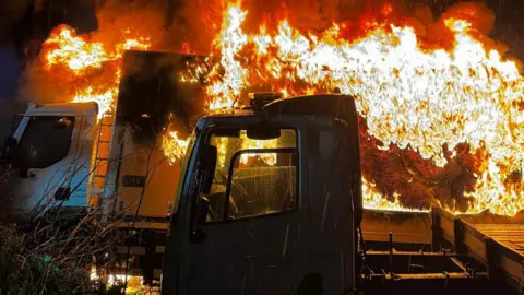 Essex County Fire & Rescue Two lorries with one at behind engulfed in flames