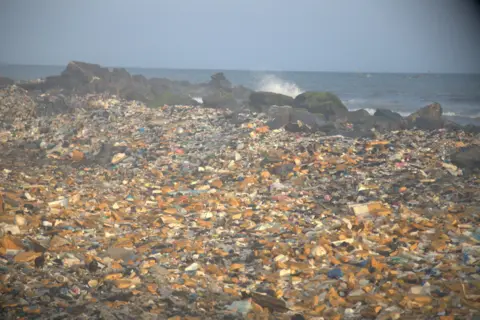 Plastik dan sampah lainnya termasuk limbah elektronik dicuci kembali oleh laut di kawasan tepi laut Jamestown di Accra