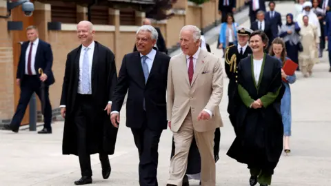 PA Media King Charles III (centre) is guided around the Oxford Centre for Islamic Studies by the director Farhan Nizami (centre left) alongside Chancellor of the University of Oxford William Hague (left).