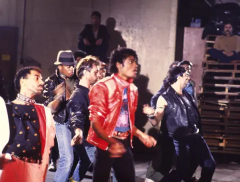 Getty Images Michael Jackson in the video for Beat it, wearing red leather jacket and black jeans, surrounded by dancers