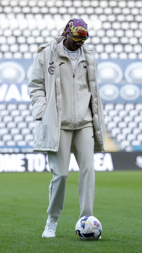 Reuters Swansea City co-owner Snoop Dogg on the pitch with a football before the match
