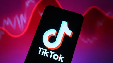 TikTok logo shown on a smartphone against a backdrop illustrating rising and falling reports with a red line