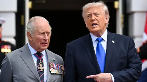 PA Media King Charles and President Donald Trump standing outside, with Trump pointing a finger at Charles. 
