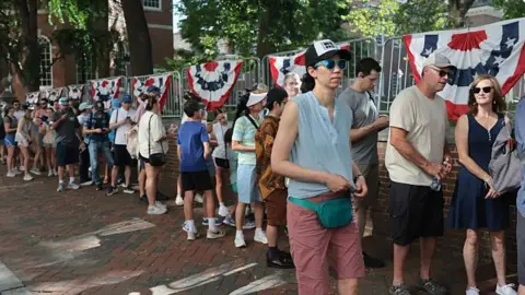 Getty Images People queuing up outside Independence Hall after news that the Salute to Independence Semiquincentennial Parade has been cancelled 