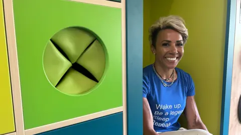 Former Olympian Dame Kelly Holmes on a visit to Le Rondin School on Guernsey. She is wearing a blue T-shirt which reads: "Wake up. Be a legend. Sleep. Repeat".