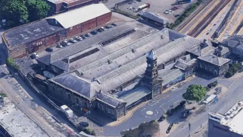 Align Property Services An aerial view of Scarborough Station. A railway line comes in and out of the station, hidden by a roof. Roads surround the perimeter of the building.