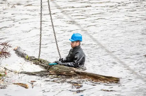 Durham County Council Fallen tree being removed from the weir by a specialist worker