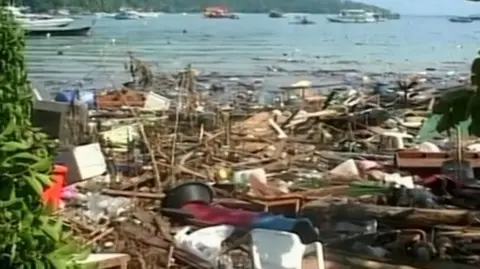 Wrecked harbour area, debris everywhere