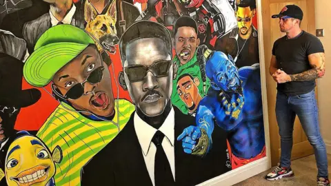 Adam Salisbury Adam Salisbury wearing a black baseball cap, black t-shirt and jeans with black, white and red trainers, stands by his mural on a wall in a house of actor Will Smith.