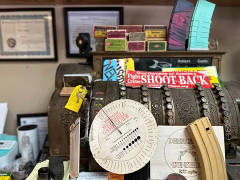 The old cash register was decorated with a sign that said "Fight crime, shoot again"