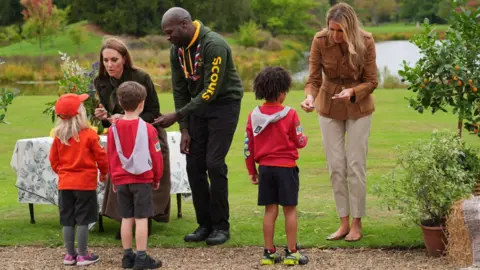 PA Medios La Princesa de Gales (izquierda) y la Primera Dama Melania Trump presentan "Volverse loco" Insignias mientras se encuentran con miembros del programa de ardillas de los Scouts en Frogmore Garden