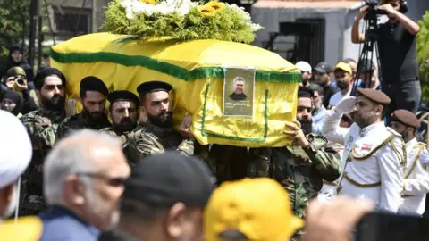 Getty Images Taleb Abdallah's coffin is carried by men in military dress