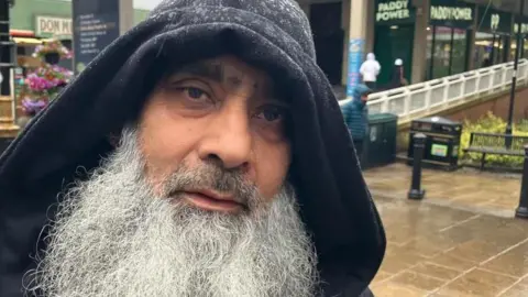 Sam Read/BBC Abu Jay wearing a hood