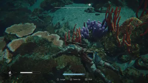 Ubisoft A screenshot. The main character swims underwater, dressed in full pirate garb. We see brightly coloured coral in orange, purple and yellow at the bottom of the water.