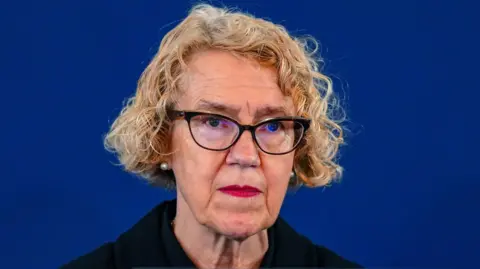 Pa Media Lady Justice Thirawall, who suffers from curly blond hair and is photographed wearing dark glasses. It is in front of a dark blue background.