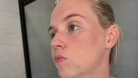 PC Wood has dyed blonde hair in a bun