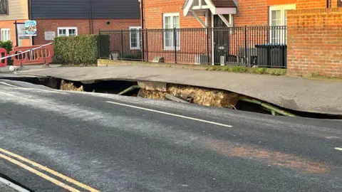 BBC/Adrian membahayakan pandangan lain dari lubang pembuangan di Godstone High Street.