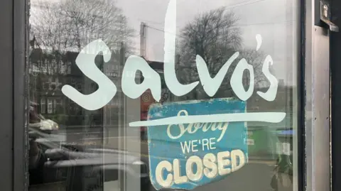 Elizabeth Baines/BBC A close-up of the door of Salvo's restaurant with a sign which says sorry we're closed 