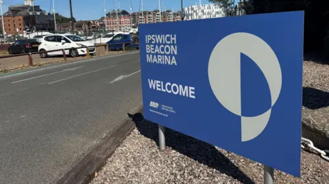George King/BBC A large blue and white sign which reads Ipswich Beacon Marina Welcome.