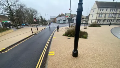 A view of a newly laid and marked cycle path towards a road in Trowbridge town centre