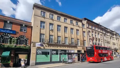 A general view of the four-storey St Aldate's Chambers in St Aldate's in Oxford, with a bus parked to the side of it 