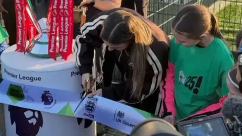 Mry Earps cutting ribbon to inugurate new football pitch