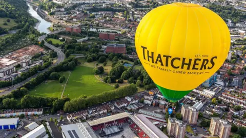 Simon Boddy/Ambitious PR A Thatchers hot air balloon hovers over Ashton Gate Stadium in Bristol with the River Avon visible in the distance