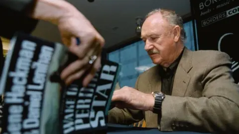 Getty Images Gene Hackman menandatangani salinan novel pertamanya