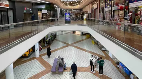 An almost empty Ridings shopping centre with just a few visitors and several closed shops.